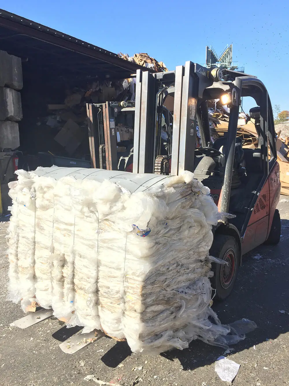 Forklift carrying a pile of recycled plastic