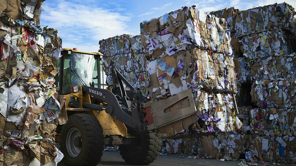 Forklift carrying a pile of recycled waste paper